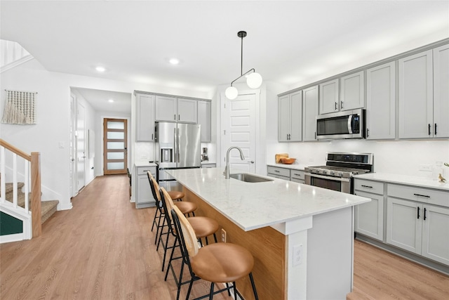 kitchen with appliances with stainless steel finishes, a sink, gray cabinets, and recessed lighting