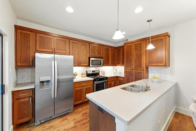 610 Fletcher St Unit A, Austin, TX 78704 - kitchen with appliances with stainless steel finishes, a sink, a peninsula, brown cabinets, and light countertops