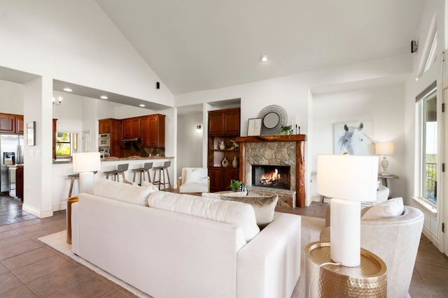 432 Stacey Ann Cv, Dripping Springs, TX 78620 - living area with a stone fireplace, light tile patterned floors, recessed lighting, and high vaulted ceiling