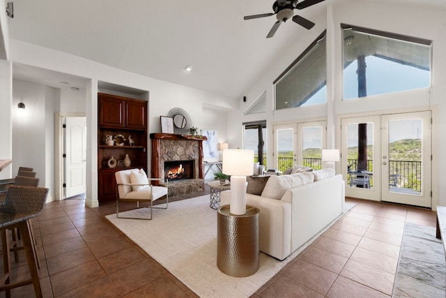 432 Stacey Ann Cv, Dripping Springs, TX 78620 - living area with light tile patterned floors, plenty of natural light, a ceiling fan, a fireplace, and high vaulted ceiling