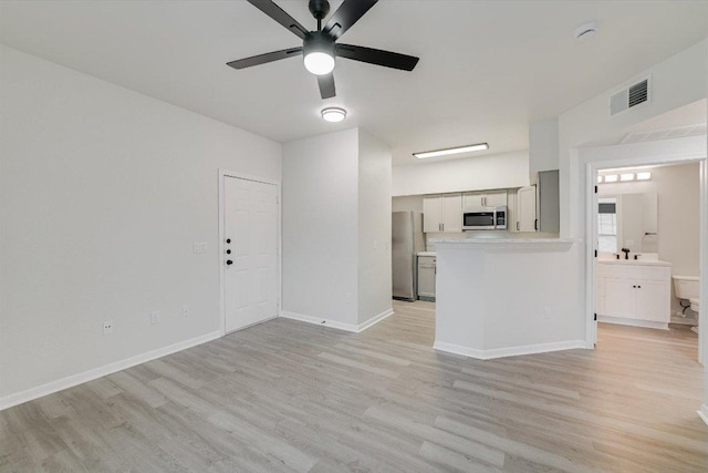 unfurnished living room featuring light wood-style flooring, a ceiling fan, and baseboards