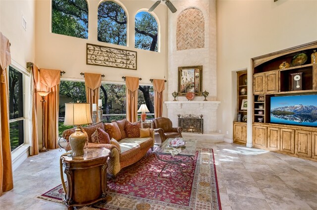 105 Hill Valley Cv, Georgetown, TX 78628 - living room with a towering ceiling, a large fireplace, ceiling fan, and light stone finish floors