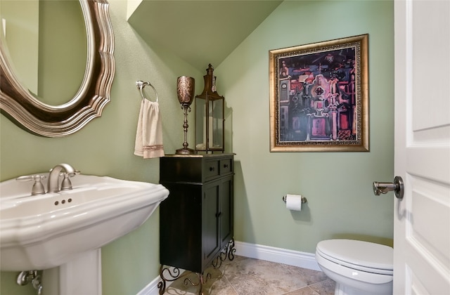 105 Hill Valley Cv, Georgetown, TX 78628 - half bath featuring a sink, lofted ceiling, toilet, baseboards, and tile patterned flooring