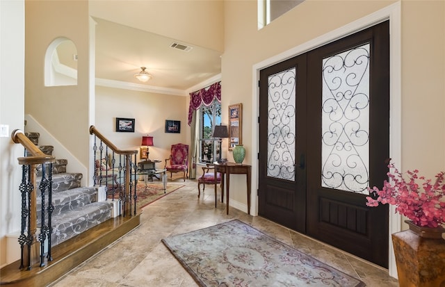 foyer entrance featuring stairs, french doors, and ornamental molding