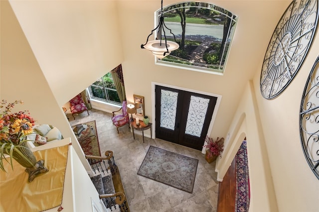 foyer entrance with french doors and a towering ceiling