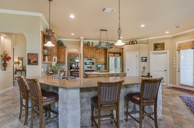 kitchen with appliances with stainless steel finishes, brown cabinetry, crown molding, recessed lighting, and a peninsula