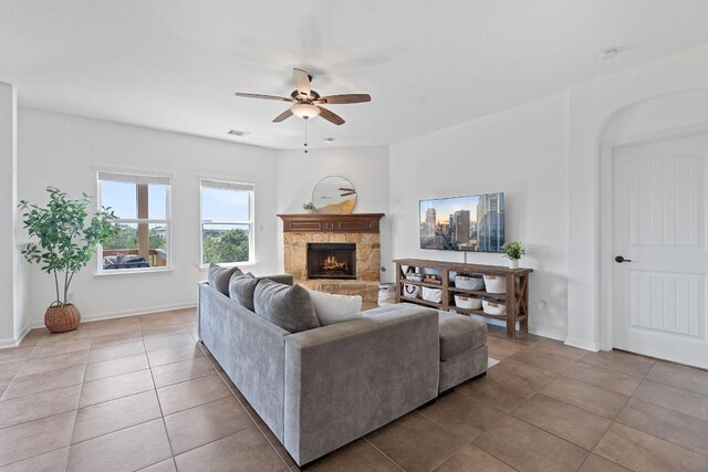 407 Stone View Trl, Austin, TX 78737 - tiled living area featuring a ceiling fan, a stone fireplace, and baseboards