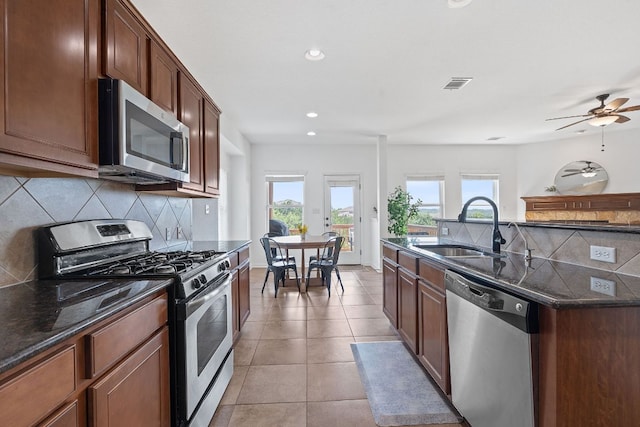 407 Stone View Trl, Austin, TX 78737 - kitchen with appliances with stainless steel finishes, a sink, tasteful backsplash, dark stone counters, and recessed lighting