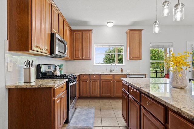 kitchen with appliances with stainless steel finishes, decorative backsplash, plenty of natural light, and light stone countertops