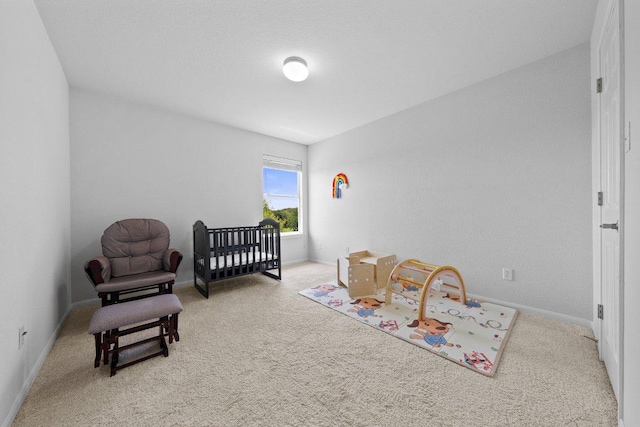 bedroom with carpet, baseboards, and a crib