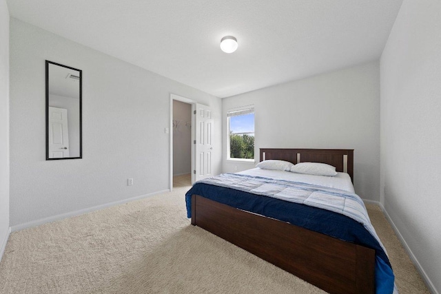 bedroom featuring carpet, baseboards, and a walk in closet