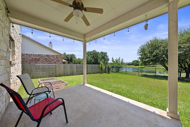 view of patio with a water view and ceiling fan