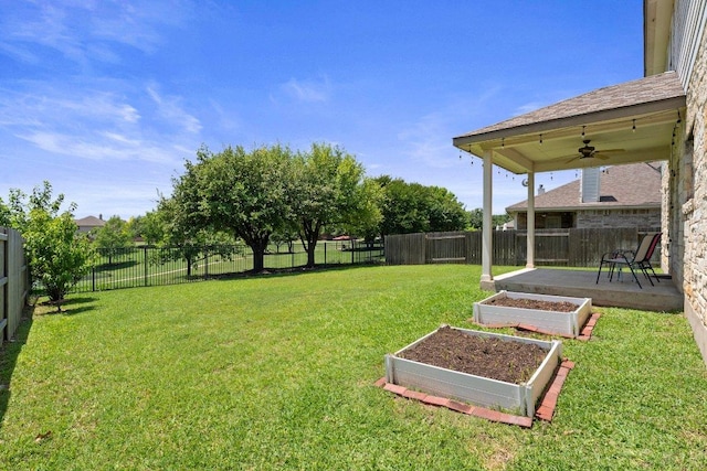 view of yard featuring a ceiling fan and a garden