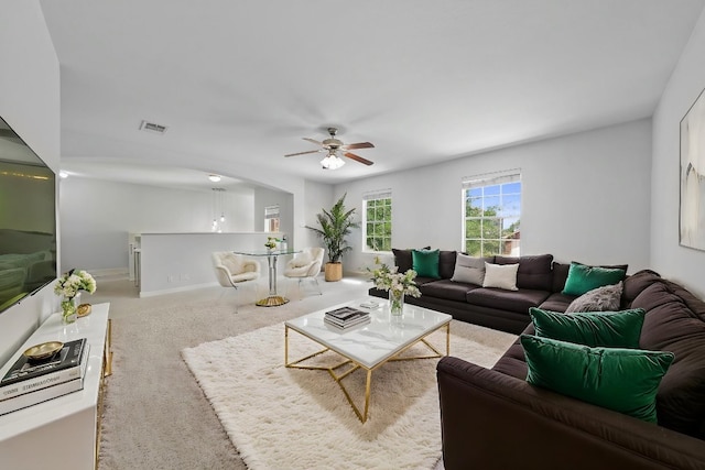 living area with ceiling fan and carpet