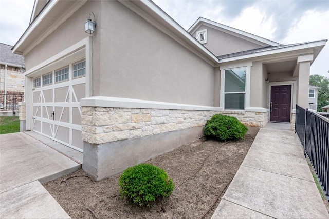 9005 Pin Brush Dr, Austin, TX 78748 - view of side of property with stone siding, stucco siding, an attached garage, and concrete driveway