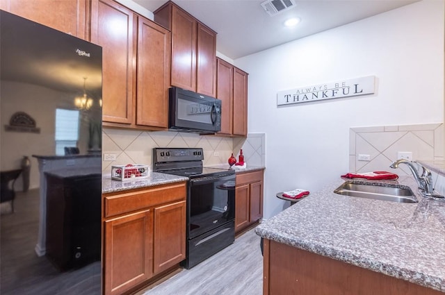 9005 Pin Brush Dr, Austin, TX 78748 - kitchen featuring black appliances, a sink, backsplash, and light wood-style floors