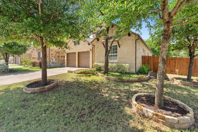 obstructed view of property featuring stone siding, driveway, and a garage