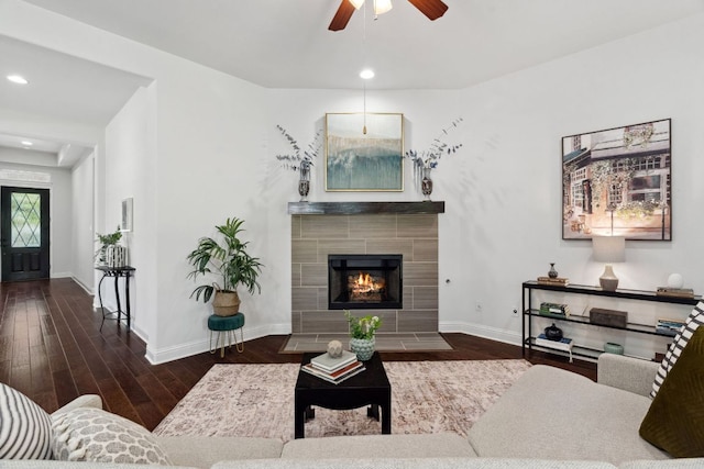 living area with wood finished floors, baseboards, ceiling fan, recessed lighting, and a tiled fireplace