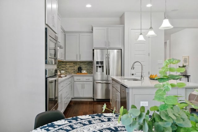 4113 Rainy Creek Ln, Cedar Park, TX 78613 - kitchen featuring appliances with stainless steel finishes, a sink, light countertops, dark wood finished floors, and tasteful backsplash