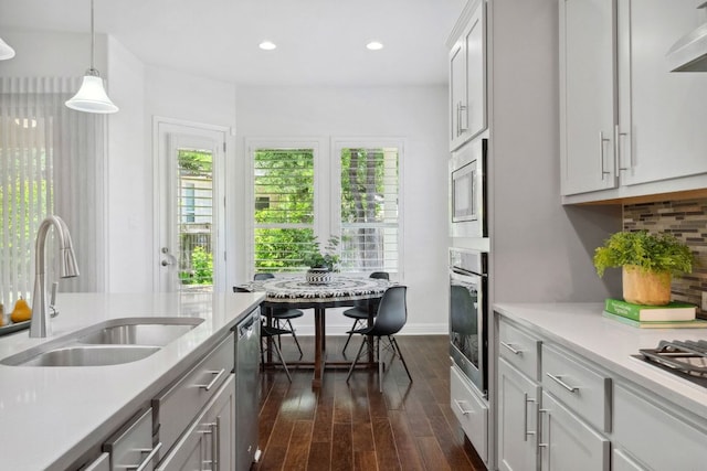 kitchen featuring a sink, appliances with stainless steel finishes, dark wood-style floors, healthy amount of natural light, and recessed lighting