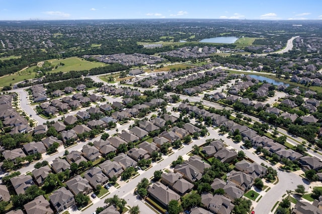 aerial view of property and surrounding area featuring a large body of water and nearby suburban area