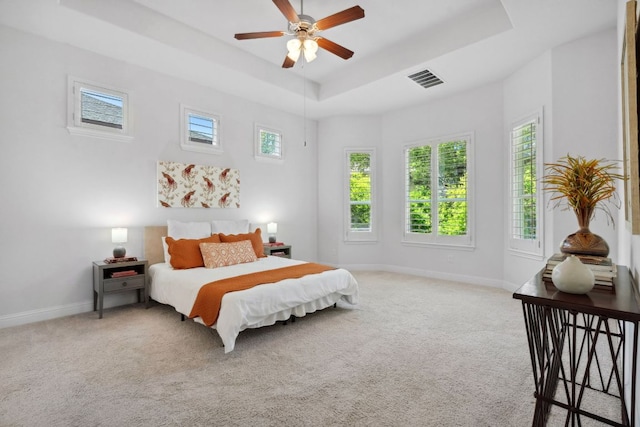 bedroom featuring multiple windows, light colored carpet, and baseboards