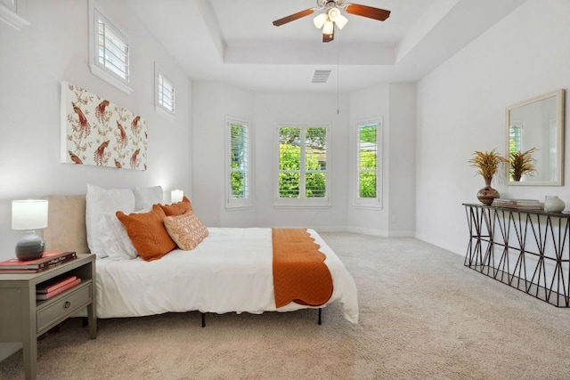 bedroom with carpet, a tray ceiling, ceiling fan, and baseboards