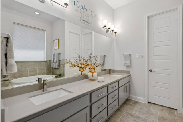 full bath with double vanity and baseboards