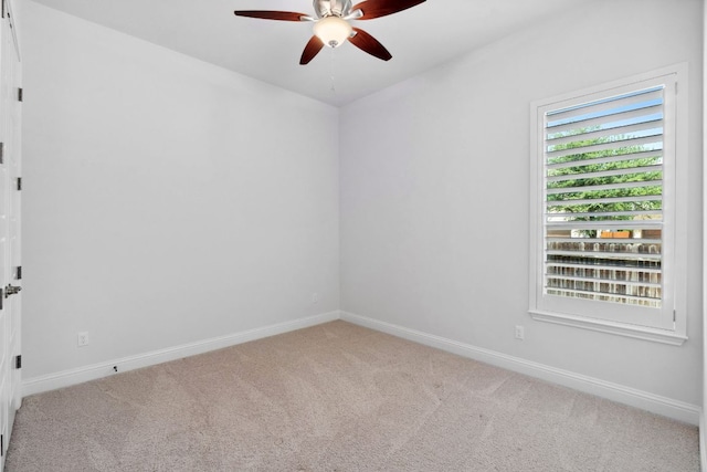 empty room featuring ceiling fan, carpet, and baseboards
