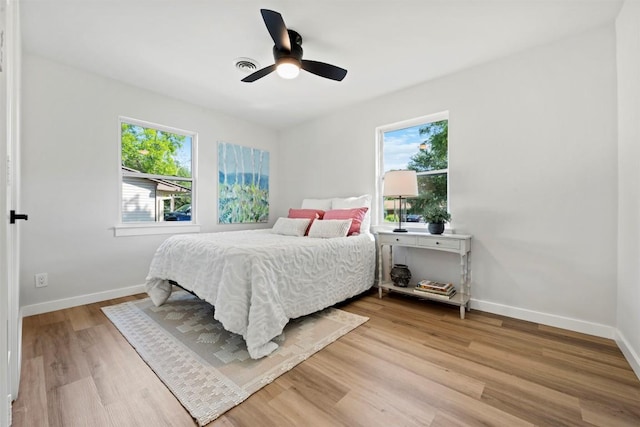 616 Bissonet Ln, Austin, TX 78752 - bedroom with multiple windows, light wood-style flooring, and a ceiling fan