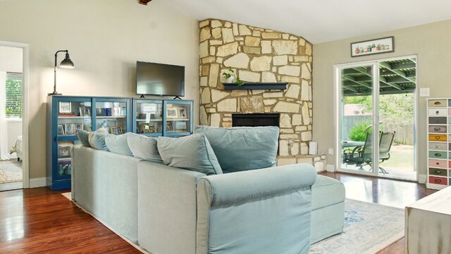 708 Chestnut Xing, Cedar Park, TX 78613 - living room with wood finished floors, vaulted ceiling, baseboards, and a stone fireplace