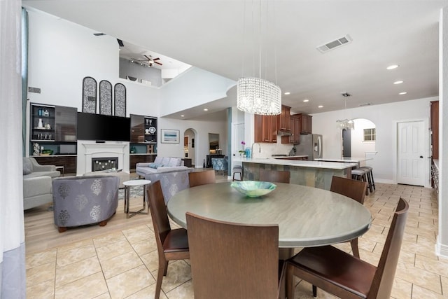 905 S Frontier Ln, Cedar Park, TX 78613 - dining area with a chandelier, a ceiling fan, recessed lighting, a fireplace, and arched walkways