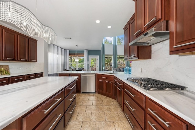 kitchen with appliances with stainless steel finishes, light countertops, decorative backsplash, under cabinet range hood, and recessed lighting