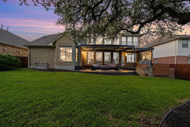 back of property at dusk featuring outdoor lounge area, a patio, and stone siding