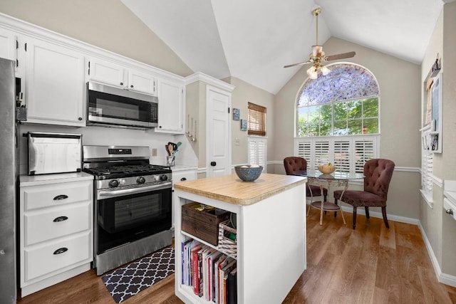 kitchen with stainless steel appliances, ceiling fan, lofted ceiling, light countertops, and wood finished floors
