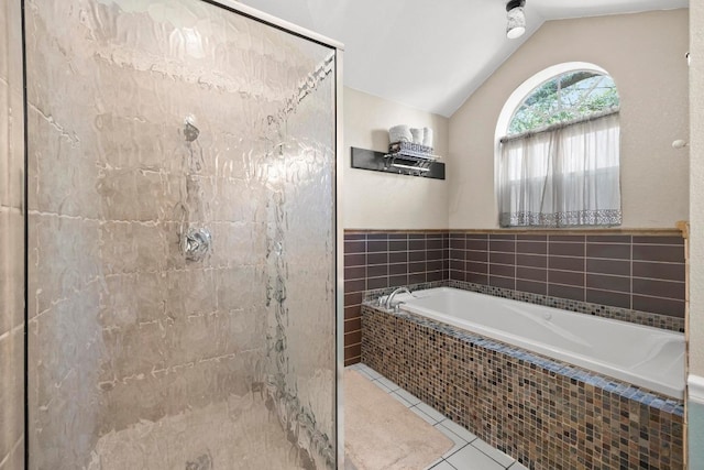 bathroom featuring lofted ceiling, tile patterned floors, a stall shower, and a garden tub