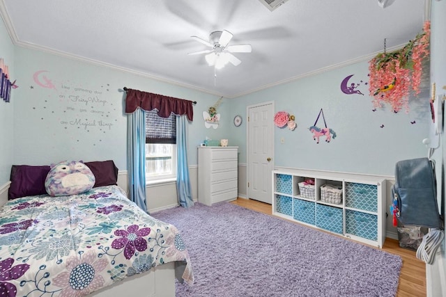 bedroom featuring crown molding, ceiling fan, wood finished floors, and baseboards