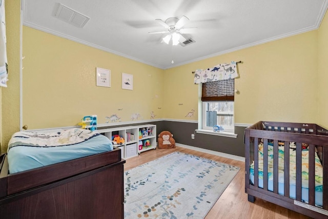 bedroom with wood finished floors, crown molding, ceiling fan, and baseboards