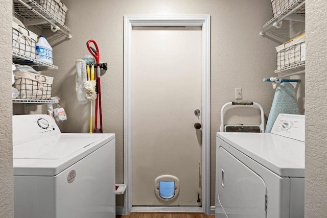 washroom featuring washing machine and clothes dryer and a textured wall