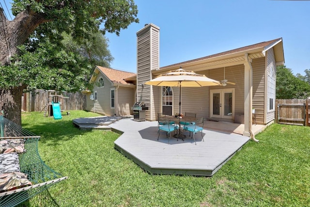 back of house featuring french doors, a deck, ceiling fan, and a chimney