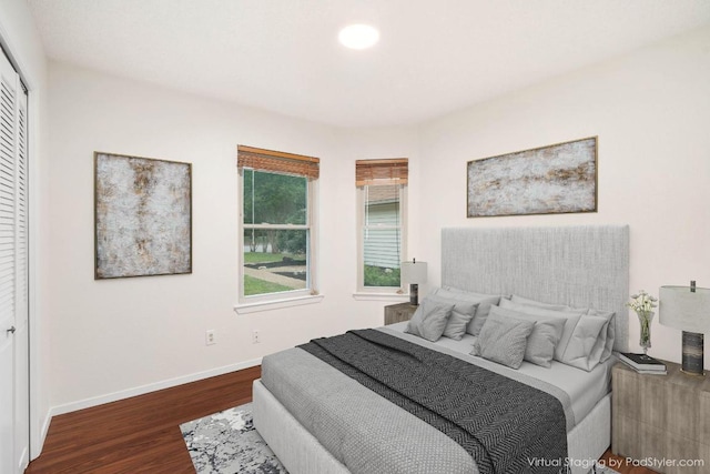 bedroom featuring wood finished floors, baseboards, and a closet