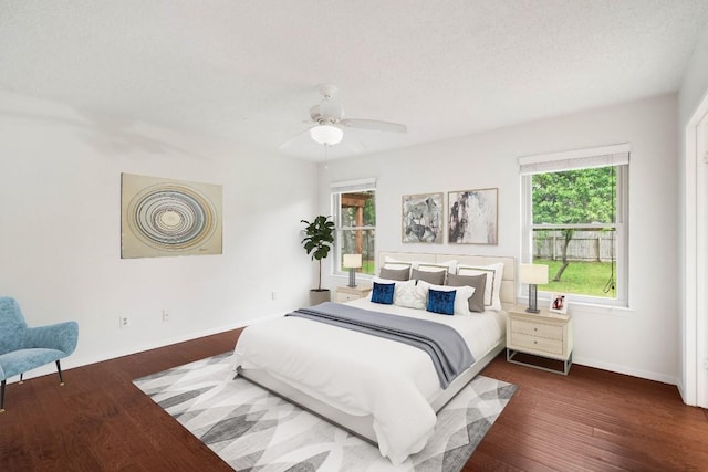 bedroom with baseboards, wood finished floors, and a ceiling fan