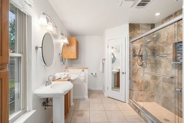 full bath featuring a stall shower, tile patterned floors, and baseboards