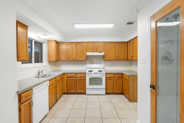 kitchen featuring white appliances, a sink, under cabinet range hood, brown cabinetry, and light tile patterned flooring