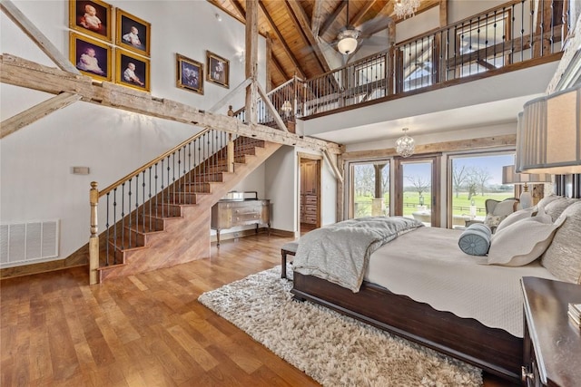 bedroom featuring high vaulted ceiling, wood finished floors, beam ceiling, access to exterior, and baseboards