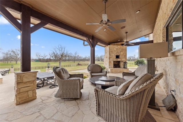 view of patio / terrace featuring an outdoor living space with a fireplace and ceiling fan