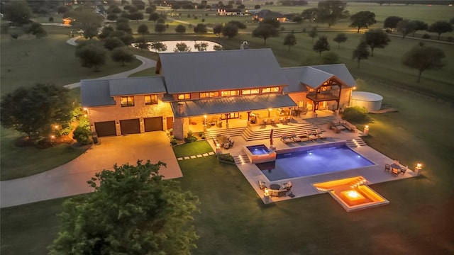 swimming pool featuring an outdoor fire pit, a yard, an in-ground hot tub, and a patio area