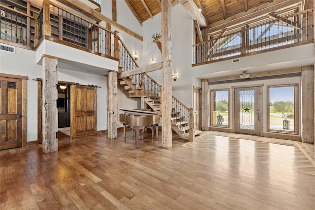 entryway featuring high vaulted ceiling, stairway, wood finished floors, wooden ceiling, and baseboards