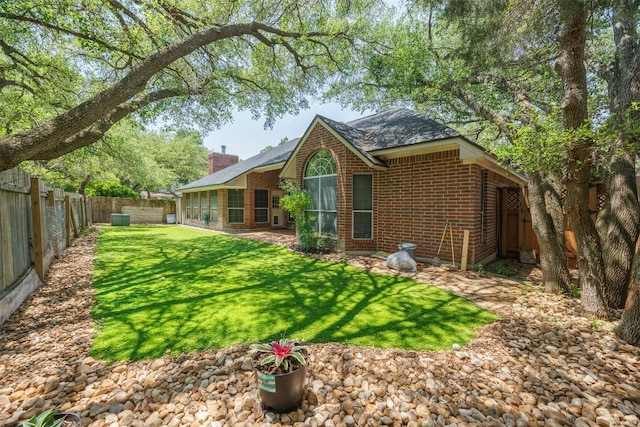2025 Saint Andrews Dr, Round Rock, TX 78664 - back of property with brick siding, a chimney, and roof with shingles