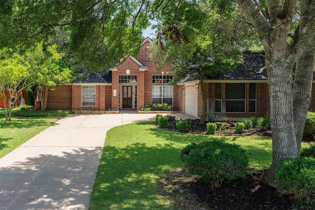 2025 Saint Andrews Dr, Round Rock, TX 78664 - view of front of house with an attached garage, brick siding, concrete driveway, and a front lawn